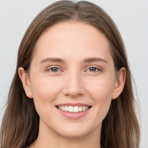 Joyful white young-adult female with long  brown hair and grey eyes