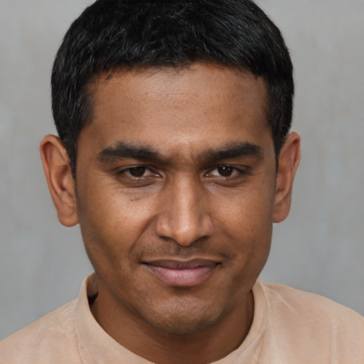 Joyful black young-adult male with short  black hair and brown eyes