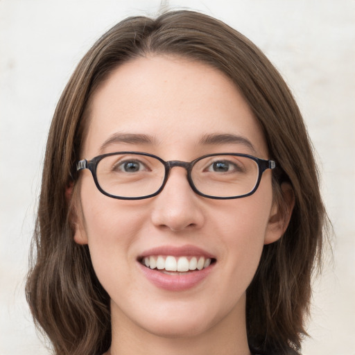 Joyful white young-adult female with medium  brown hair and grey eyes