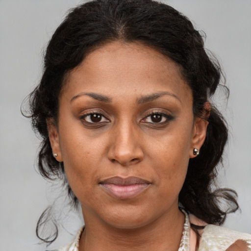 Joyful black adult female with medium  brown hair and brown eyes