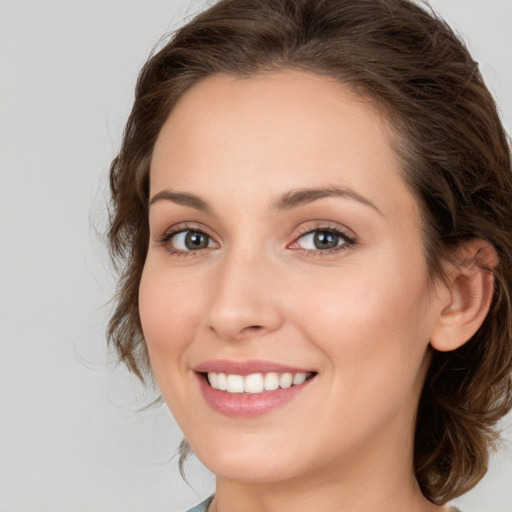 Joyful white young-adult female with medium  brown hair and green eyes