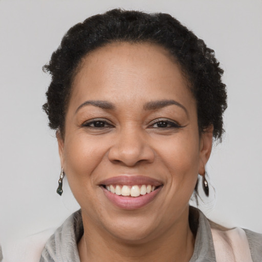 Joyful black adult female with short  brown hair and brown eyes