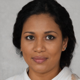 Joyful black adult female with medium  brown hair and brown eyes