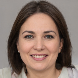 Joyful white adult female with medium  brown hair and brown eyes