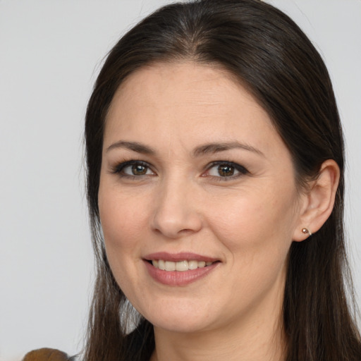 Joyful white adult female with long  brown hair and brown eyes