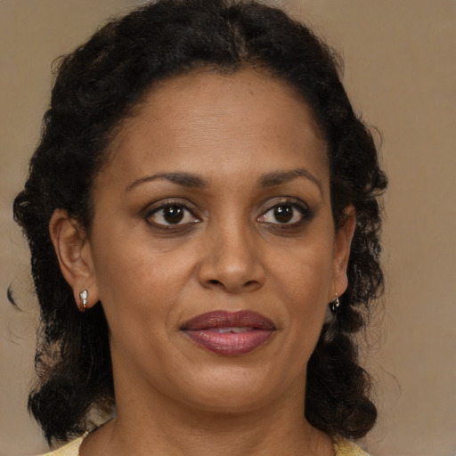 Joyful black adult female with medium  brown hair and brown eyes