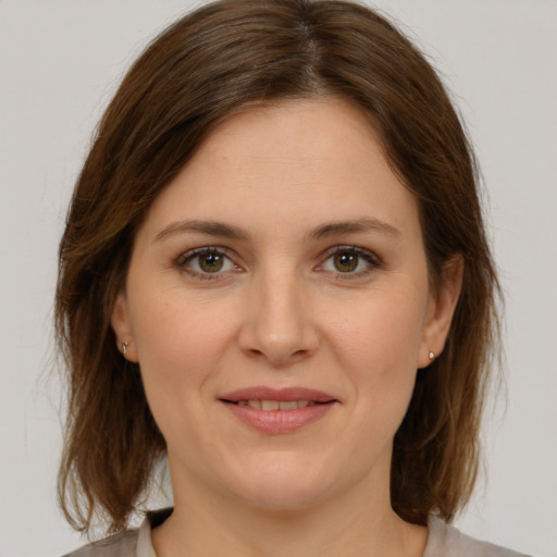 Joyful white young-adult female with medium  brown hair and green eyes