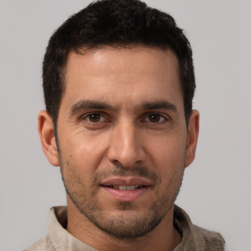 Joyful white young-adult male with short  black hair and brown eyes