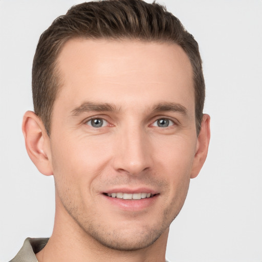 Joyful white young-adult male with short  brown hair and grey eyes