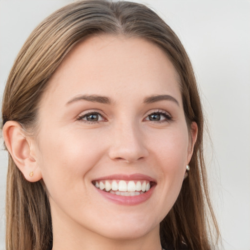 Joyful white young-adult female with long  brown hair and grey eyes