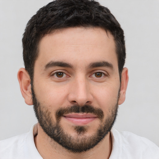 Joyful white young-adult male with short  black hair and brown eyes