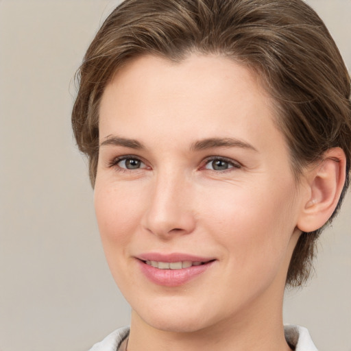 Joyful white young-adult female with medium  brown hair and grey eyes