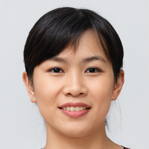 Joyful asian young-adult female with short  brown hair and brown eyes