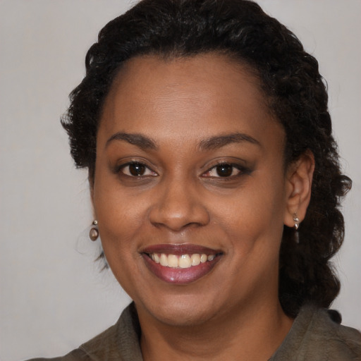 Joyful black young-adult female with long  brown hair and brown eyes