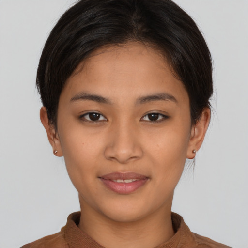 Joyful latino young-adult female with short  brown hair and brown eyes