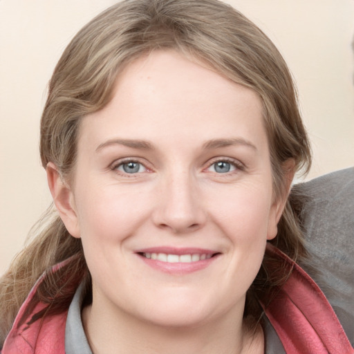 Joyful white young-adult female with medium  brown hair and blue eyes