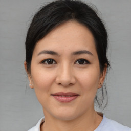 Joyful asian young-adult female with medium  brown hair and brown eyes