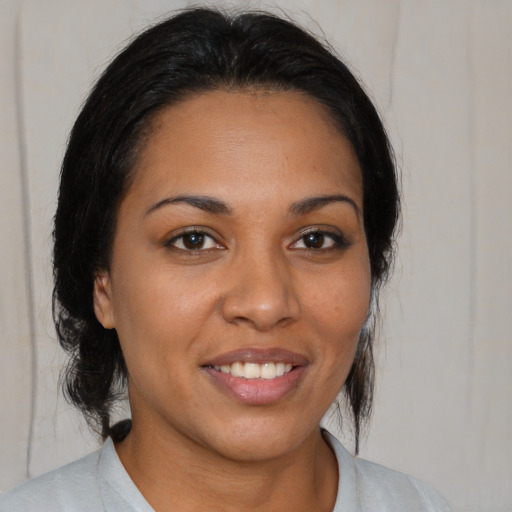 Joyful latino young-adult female with medium  brown hair and brown eyes