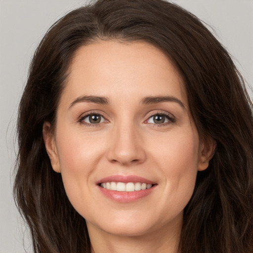 Joyful white young-adult female with long  brown hair and brown eyes