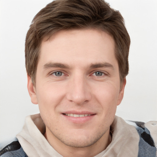 Joyful white young-adult male with short  brown hair and grey eyes