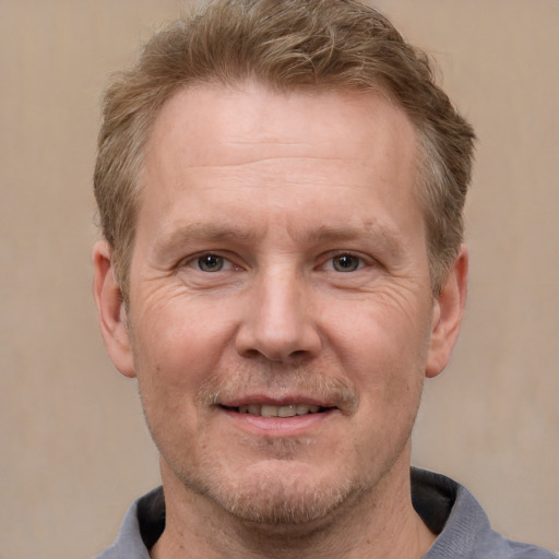 Joyful white adult male with short  brown hair and grey eyes