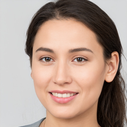 Joyful white young-adult female with long  brown hair and brown eyes