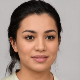 Joyful latino young-adult female with medium  brown hair and brown eyes