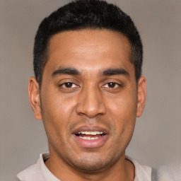 Joyful black young-adult male with short  black hair and brown eyes