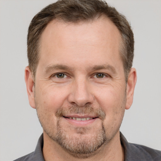 Joyful white adult male with short  brown hair and grey eyes