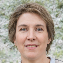 Joyful white adult female with short  brown hair and grey eyes