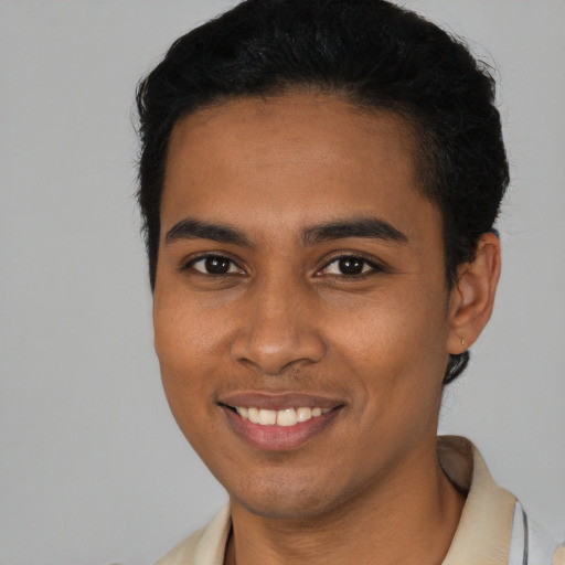 Joyful black young-adult male with short  brown hair and brown eyes