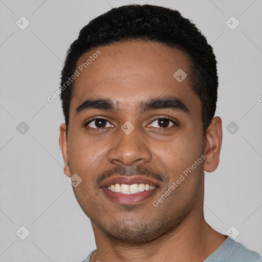 Joyful black young-adult male with short  black hair and brown eyes