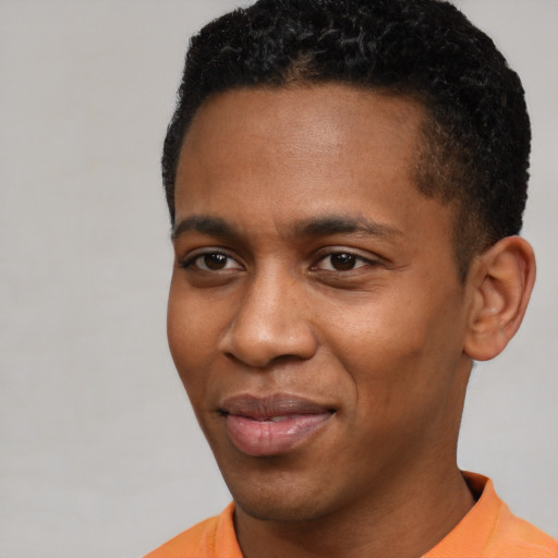 Joyful black young-adult male with short  black hair and brown eyes