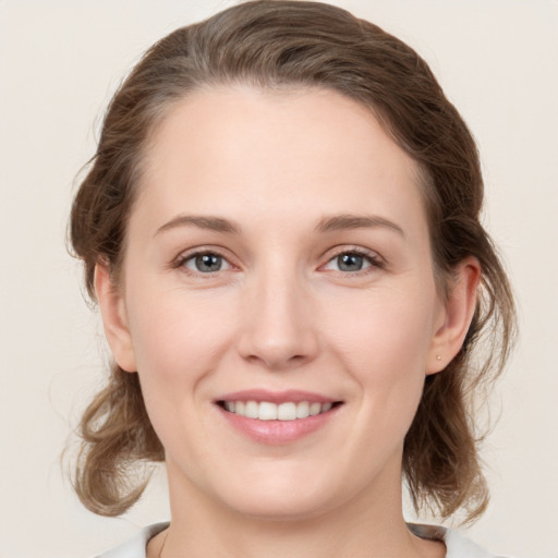 Joyful white young-adult female with medium  brown hair and grey eyes