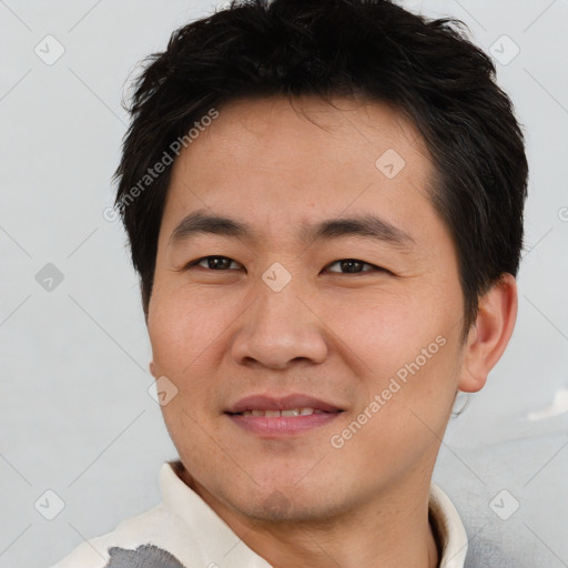 Joyful asian young-adult male with short  brown hair and brown eyes