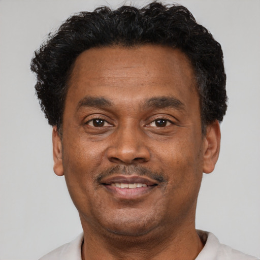 Joyful latino adult male with short  brown hair and brown eyes