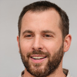 Joyful white adult male with short  brown hair and brown eyes