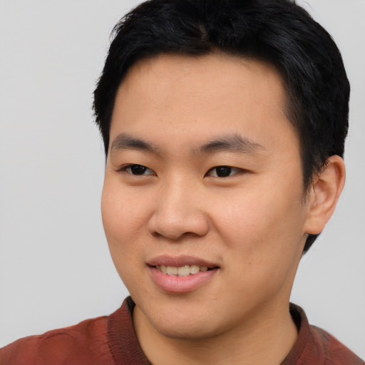Joyful asian young-adult male with short  black hair and brown eyes