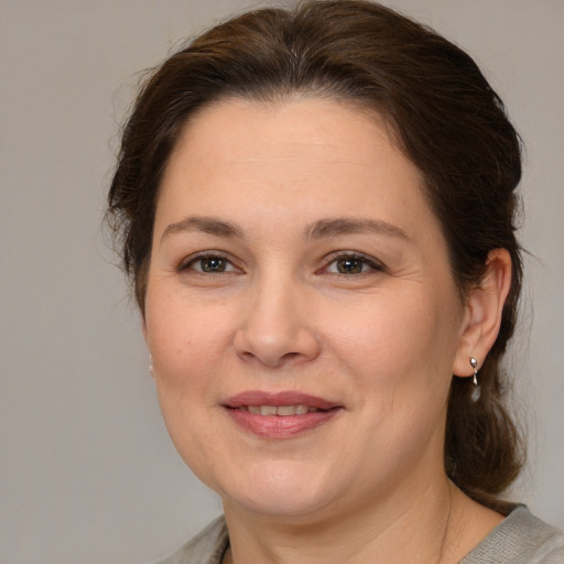 Joyful white adult female with medium  brown hair and brown eyes