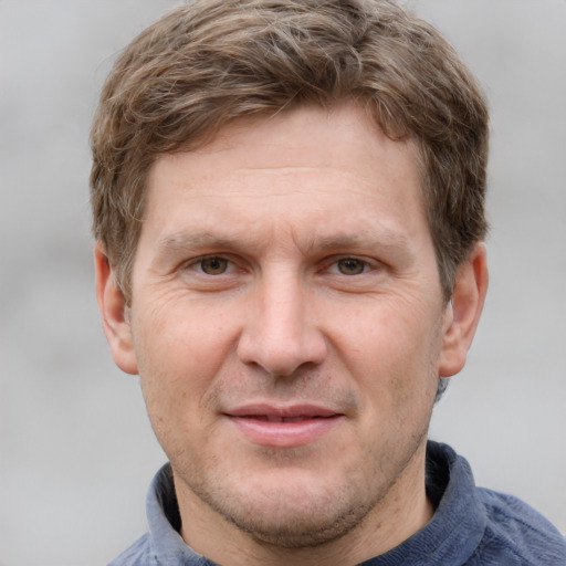 Joyful white adult male with short  brown hair and grey eyes