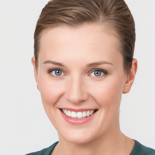 Joyful white young-adult female with short  brown hair and grey eyes