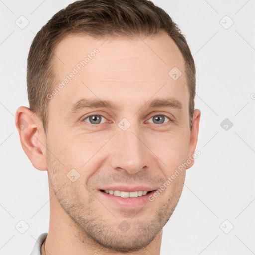 Joyful white young-adult male with short  brown hair and grey eyes