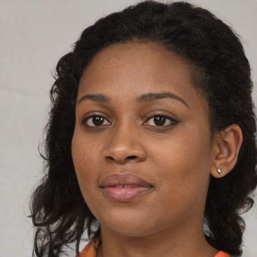 Joyful black young-adult female with long  brown hair and brown eyes