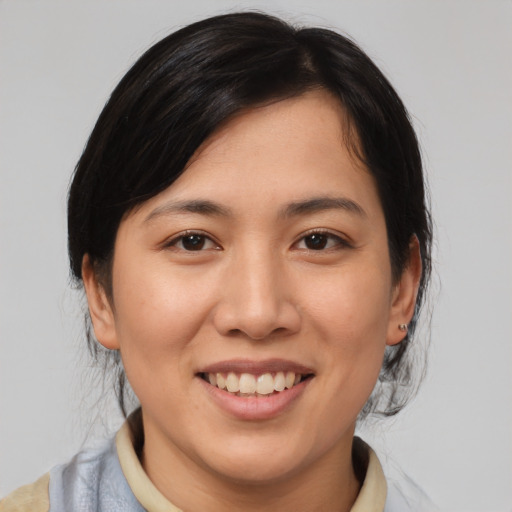 Joyful asian young-adult female with medium  brown hair and brown eyes