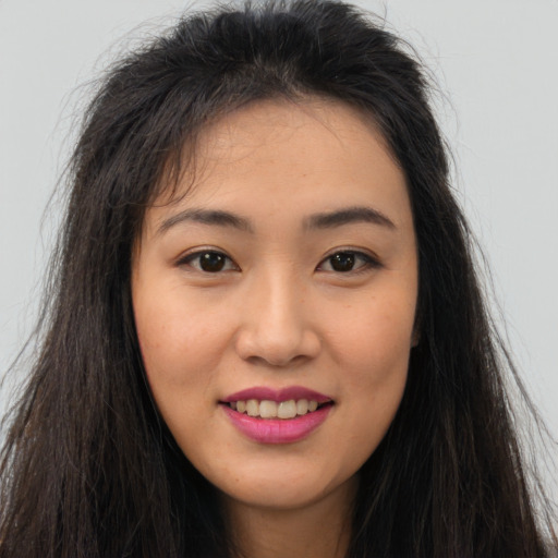 Joyful asian young-adult female with long  brown hair and brown eyes