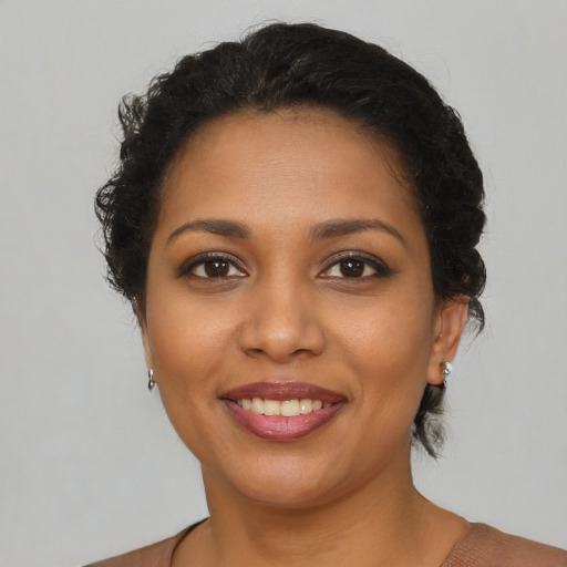 Joyful latino young-adult female with short  brown hair and brown eyes
