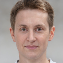 Joyful white young-adult male with short  brown hair and grey eyes