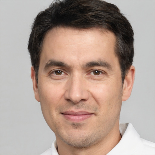 Joyful white adult male with short  black hair and brown eyes