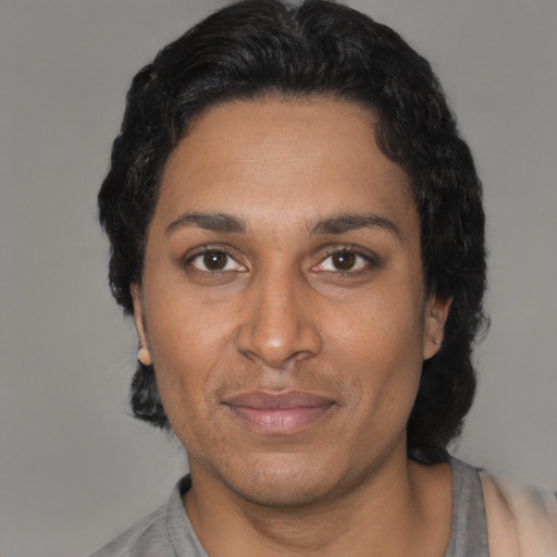 Joyful black adult female with short  black hair and brown eyes