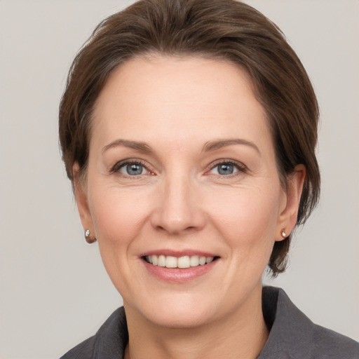 Joyful white adult female with medium  brown hair and grey eyes